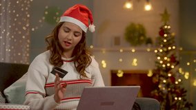 Happy woman with Santa hat shopping online using credit card on laptop during festive christmas celebration - concept of ecommerce payment, holiday offers or sales and banking. - Powered by Shutterstock - Get 15% off with code: PIKWIZARD15