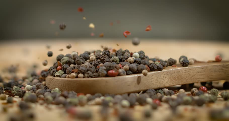 Mixed peppercorns in a super slow motion. Dry mix peppercorns close up.