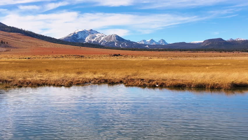 Aerial View of Mammoth Mountain Snow Capped Peaks above Pond