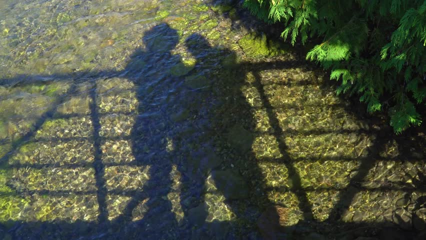 Silhouette of couple travellers tourist enjoy their vacation. Romantic view of two people shapes, man and woman together on bridge of Manitou River near Sandfield Dam, Lake Manitou. Family adventure.