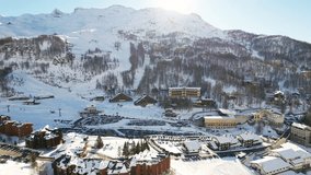 Panoramic aerial drone scenic view at ski slopes, mountain skiing and popular resort town. Italian ski resort in Alps in Aosta Valley in winter. 
