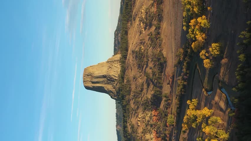 Devils Tower Butte and Belle Fourche River in Sunny Autumn Morning. Crook County. Wyoming, USA. Aerial View. Drone is Orbiting. Vertical Video