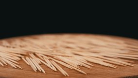Lots of Scattered Brown Toothpicks Rotate on a Wooden Background. Black background. Texture of sharp bamboo wooden toothpicks. Home oral care after meals. Teeth cleaning. Blurred motion. Dentistry. - Powered by Shutterstock - Get 15% off with code: PIKWIZARD15