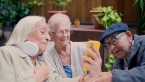 Three senior people of a geriatric using phone and smiling