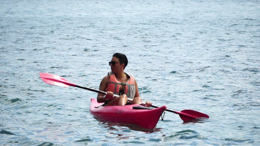 Sea woman kayak. Happy woman in life jacket paddling the kayak on sea. Female is enjoying her summer vacations at beach. Woman Exploring Calm Sea By Canoe On Holiday Vacation Weekend.