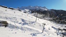 Panoramic aerial drone scenic view at ski slopes, mountain skiing and popular resort town situated on border Switzerland and Italy. Winter landscape 