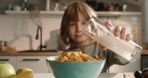 Child pouring milk into bowl of cereal, creating delightful breakfast scene. Ad slow motion cinematic. Importance of healthy nutrition for kids, cozy atmosphere of weekend morning in modern kitchen