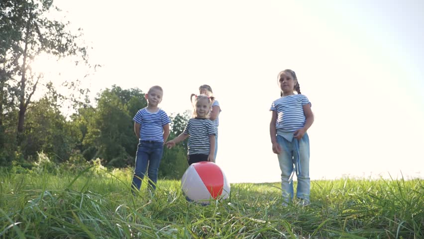 Happy family in the open air in the park. Children run after a colored inflatable ball crowd. Little kids play on the grass with the ball. Teamwork for girls and boys. Children's entertainment holiday Royalty-Free Stock Footage #3398525249