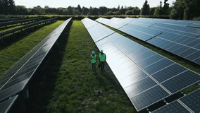 Drone shot of engineers inspecting solar panels in field generating renewable energy - shot in slow motion - Powered by Shutterstock - Get 15% off with code: PIKWIZARD15