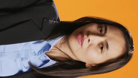 Vertical Video Filipino woman showing stop sign with palm, advertising negativity and no symbol on camera. Female model wearing formal attire in studio, showcasing rejection and refusing something. - Powered by Shutterstock - Get 15% off with code: PIKWIZARD15