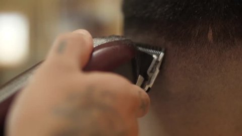 barber cutting client hair with razor electric slow motion