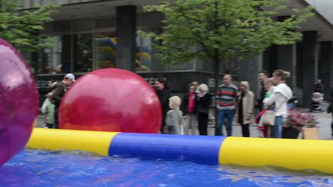 Children zorb balls swim play in pool basin and parents in Vilnius Gediminas prospect on September in Vilnius. Vilnius city capital festival.