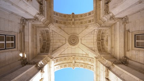 Famous Augusta arch - Arco da Rua Augusta, situated Commerce Square - Praça do Comércio - Downtown Lisbon. Portugal. Camera spinning under the arch. Beautiful architecture details. Blue sky.  Arkivvideo