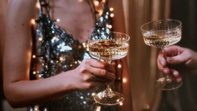 A girl holds glasses of champagne in her hands, cheers with a man. Le coupe cocktail glasses. Celebrates the New Year or a corporate holiday. Disco or retro style. They bump glasses, clink glasses - Powered by Shutterstock - Get 15% off with code: PIKWIZARD15