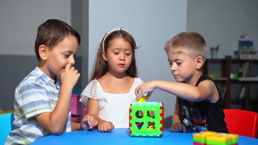 Happy Diverse School Children Having Educational Class Sitting At Desk In Classroom At School Or Kindergarten . Modern Education And Knowledge Concept. Playtime Activities. Development Kids