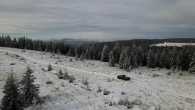 Traveling by car to the winter mountains. Wild Carpathian forest. Expedition to the mountains. Top cinematic aerial view. Ukrainian wild nature