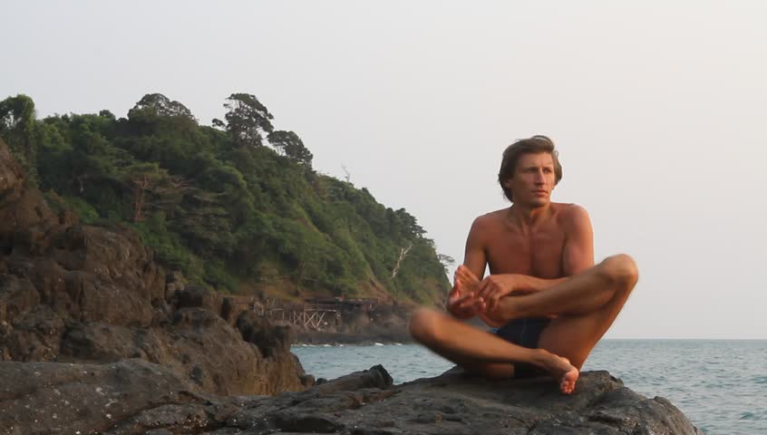 Yoga man doing exercise on the rocks by the sea (HD) 
