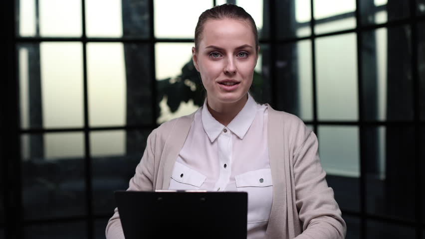Portrait of a beautiful confident young woman holding a black folder in her hands Royalty-Free Stock Footage #3399151769