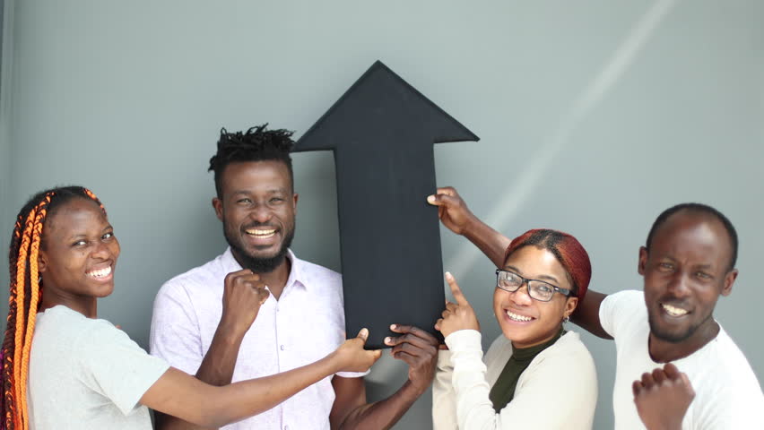 Positive corporate team holding a black arrow pointing up.