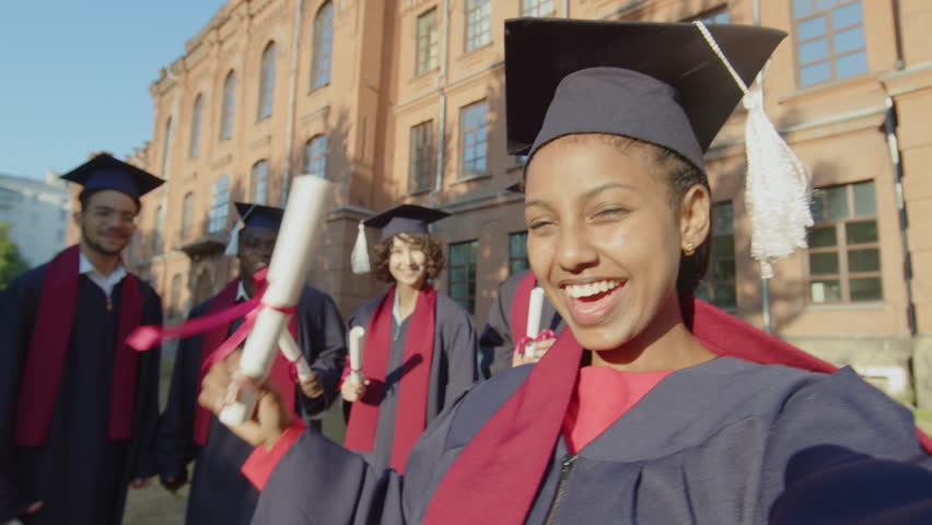 POV of group of multicultural young friends taking selfie while celebrating graduation standing against university Royalty-Free Stock Footage #3399205615