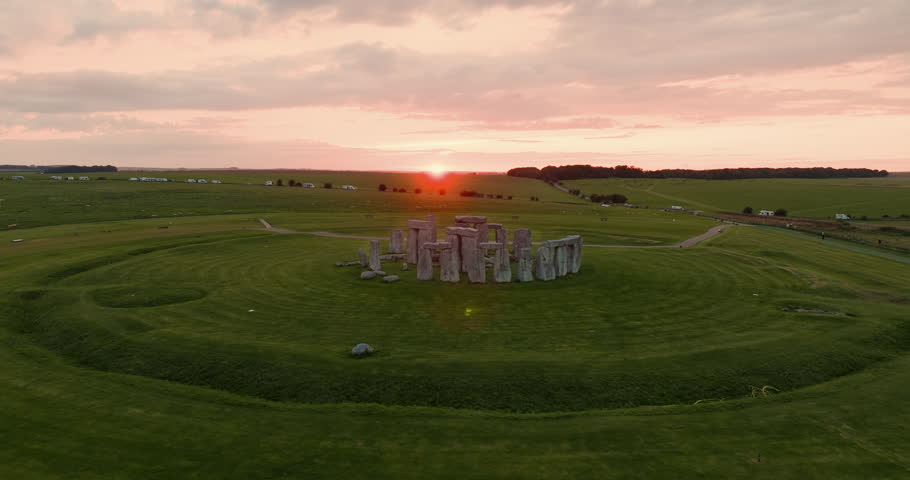 Drone flies around the iconic Stonehenge stones during breathtaking pink sunset