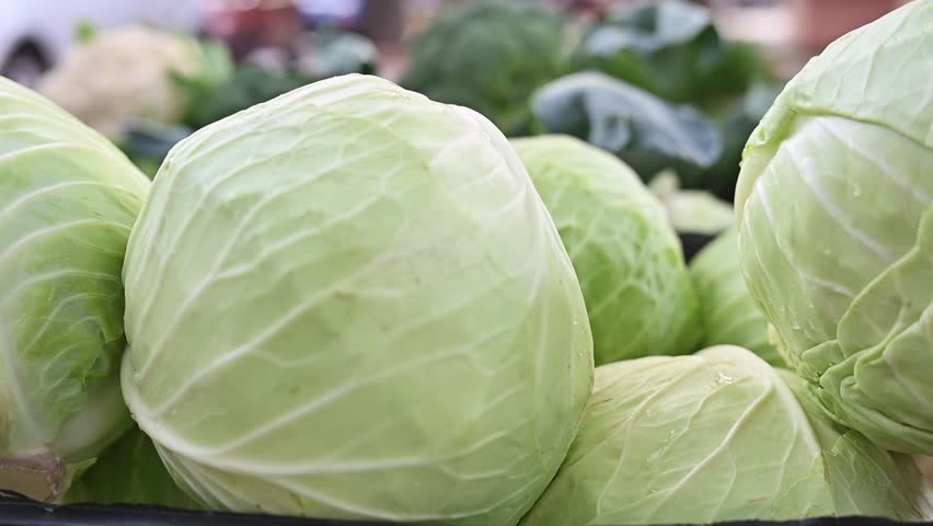 Close up of fresh whit cabbage in crate. Organic vegetables. Trading on the street from a tray. Healthy eating concept. Small farm business support. . Selective focus, slow motion