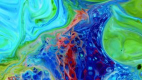 Close-up shot of multi-colored paint mixture boiling in a mixer. They form a unique abstraction that can be used in many video projects and background