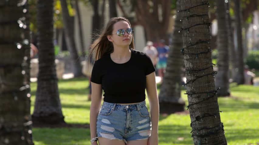 Young woman relaxes in the sun at the promenade of Miami South Beach - travel photography