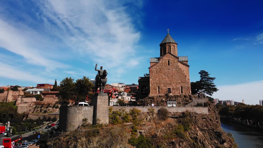 Tbilisi, Georgia - October 1, 2023: Aerial footage of ancient church and equestrian statue near it located in Tbilisi filmed by drone. Travelling to Georgia and visiting famous historical places to