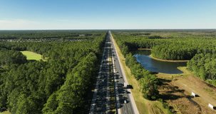 Aerial above I-95 Highway in north east part of Florida near Jacksonville. Highway among green forest, blue sky above horizon