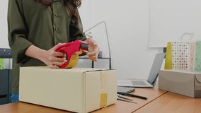 Close up woman hand packing shipment box with transparency tape at home office, happy freelance and packing cardboard box delivery products to customers, Startup small business, Moving day - Powered by Shutterstock - Get 15% off with code: PIKWIZARD15