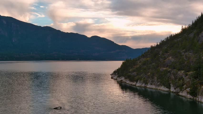 Scenic Ocean Coast and Mountains in Howe Sound. Cloudy Sunset Sky, Fall Season. Howe Sound, British Columbia Canada. Royalty-Free Stock Footage #3399496731