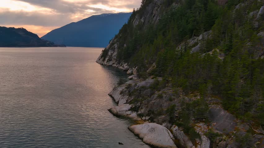 Scenic Ocean Coast and Mountains in Howe Sound. Cloudy Sunset Sky, Fall Season. Howe Sound, British Columbia Canada. Royalty-Free Stock Footage #3399496871