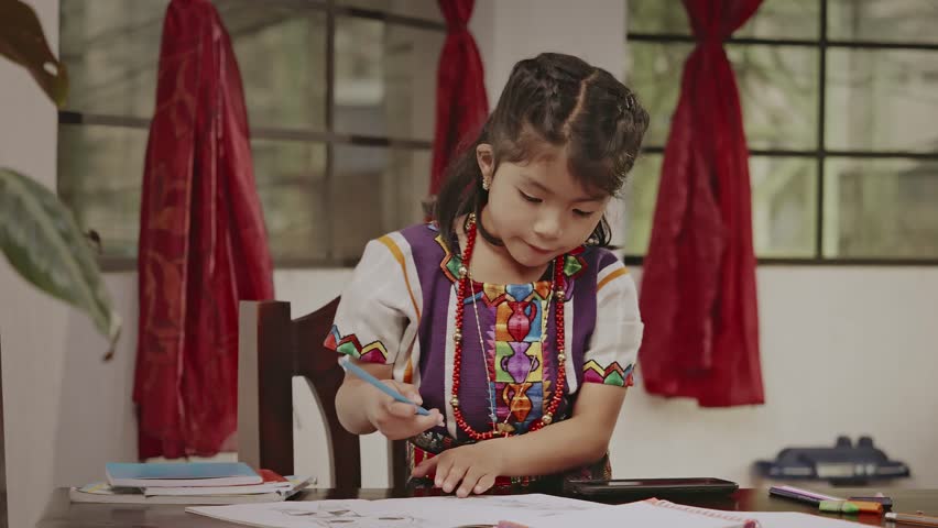 Latina girl of the Mayan ethnic group performs tasks on a table in her home. Royalty-Free Stock Footage #3399505659