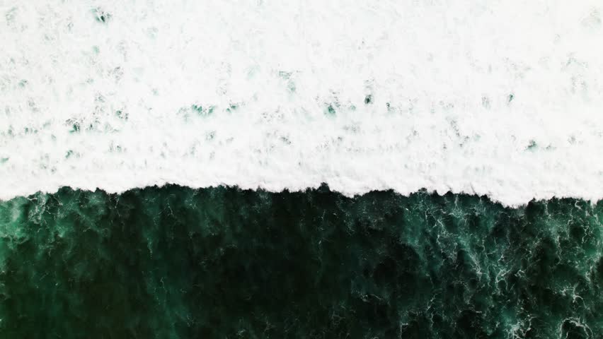Beautiful texture of big power dark ocean waves with white wash. Aerial top view footage of fabulous sea tide on a stormy day. Drone filming breaking surf with foam in Indian ocean. Big swell in Bali. Royalty-Free Stock Footage #3399659157