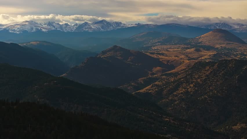 Sweeping mountain vista of forested foothills and snowy ridges of Lost Gulch Overlook Boulder Colorado at sunset