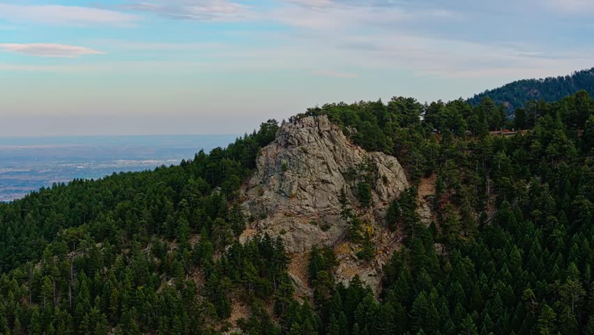 Exposed red rock ledge of quartz stands out from scrub pine forest at Lost Gulch Overlook Boulder Colorado