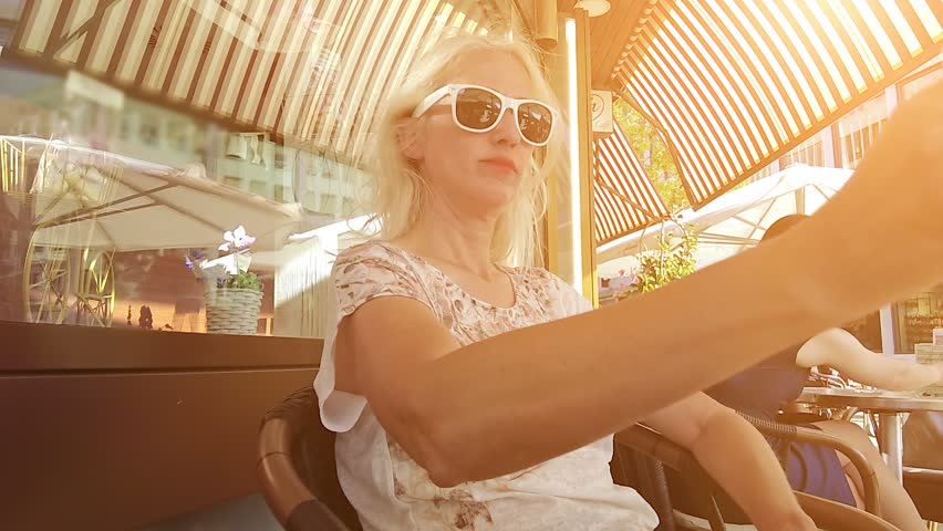SLOW MOTION: Woman tourist at sunset drinking a draft beer at sunset in the downtown roads of Chur city. Coira Swiss town in Grisons. Coira capital town of the Grisons Swiss canton of Switzerland.