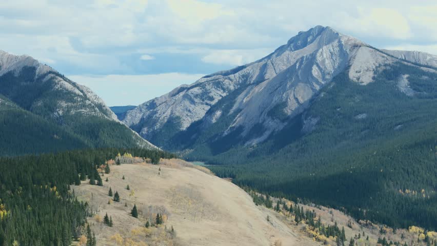 Eagle Lake nested between two giant rocky mountains is seen from an aerial drone point of view in the Ya Ha Tinda Ranch area of Alberta Canada.