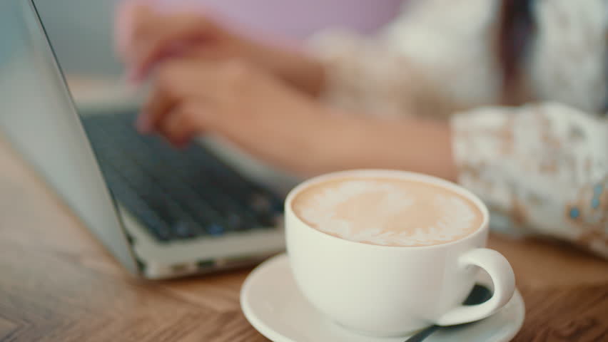 Woman hands working on laptop keyboard in cafe. 