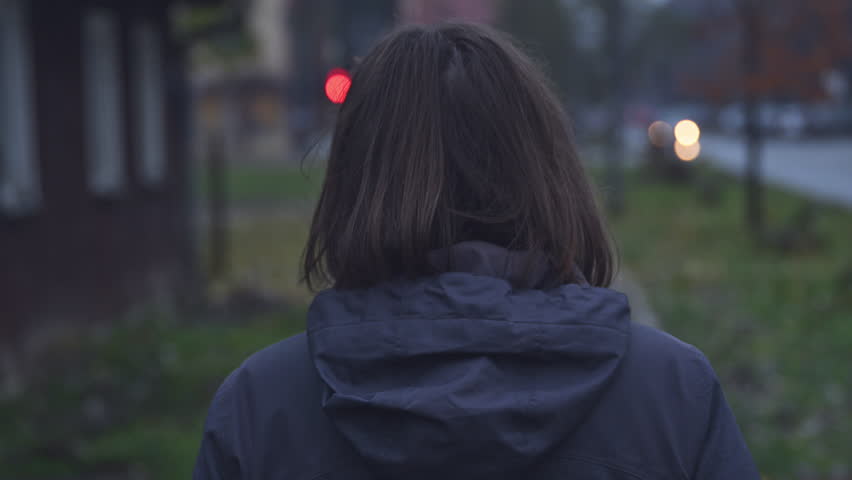 Rear view of disoriented female person walking down the street, handheld footage with selective focus Royalty-Free Stock Footage #3399835105