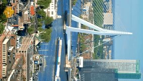 View of Rotterdam city and the Erasmus bridge Erasmusbrug over Nieuwe Maas river from Euromast with cargo ship passing under the bridge