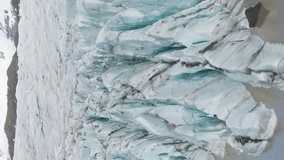 Svinafellsjokull Glacier. Ash, Cracks and Fissures. Iceland. Aerial View. Drone Flies Upwards, Tilt Down. Vertical Video - Powered by Shutterstock - Get 15% off with code: PIKWIZARD15