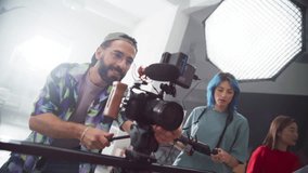 Zoom in Portrait of a Group of Young Film Students Working on their School Project. Creative Crew Filming a Fun Music Video for a Female Artist, Using High Quality Equipment. Slow Motion - Powered by Shutterstock - Get 15% off with code: PIKWIZARD15