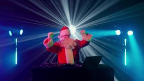 DJ Santa Claus mixing tracks in a nightclub at a Christmas and New Year party or Corporate events. Senior disc jockey as Santa listening music, headphones, laptop, mixer controller player, turntable. - Powered by Shutterstock - Get 15% off with code: PIKWIZARD15
