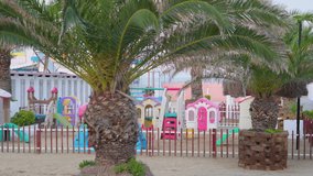 The colorful childrens playground on the beach side with the white sand on the shore in Italy
