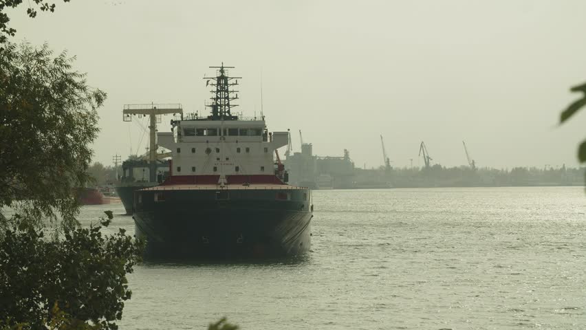 Big ship on river with port in the background