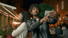 Offended Arabian woman girl girlfriend sad ignore angry to gadget phone addict blogger vlogger influencer man trying to take photo selfie for blog vlog couple problem navigation GPS in evening city - Powered by Shutterstock - Get 15% off with code: PIKWIZARD15