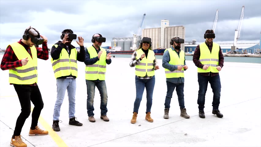 Teamwork of logistics workers,foreman, engineer working in an international shipping area spend fun time dancing with virtual reality glasses