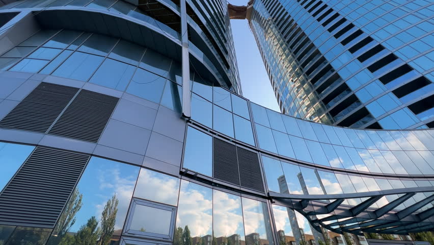 Modern glassed skyscrapers in the final stages of construction on a sunny summer day. Extreme wide low angle view. Bottom up Royalty-Free Stock Footage #3400189079